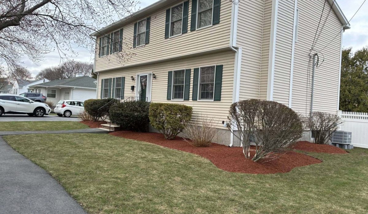 Professionally maintained front yard with trimmed shrubs and healthy residential landscaping