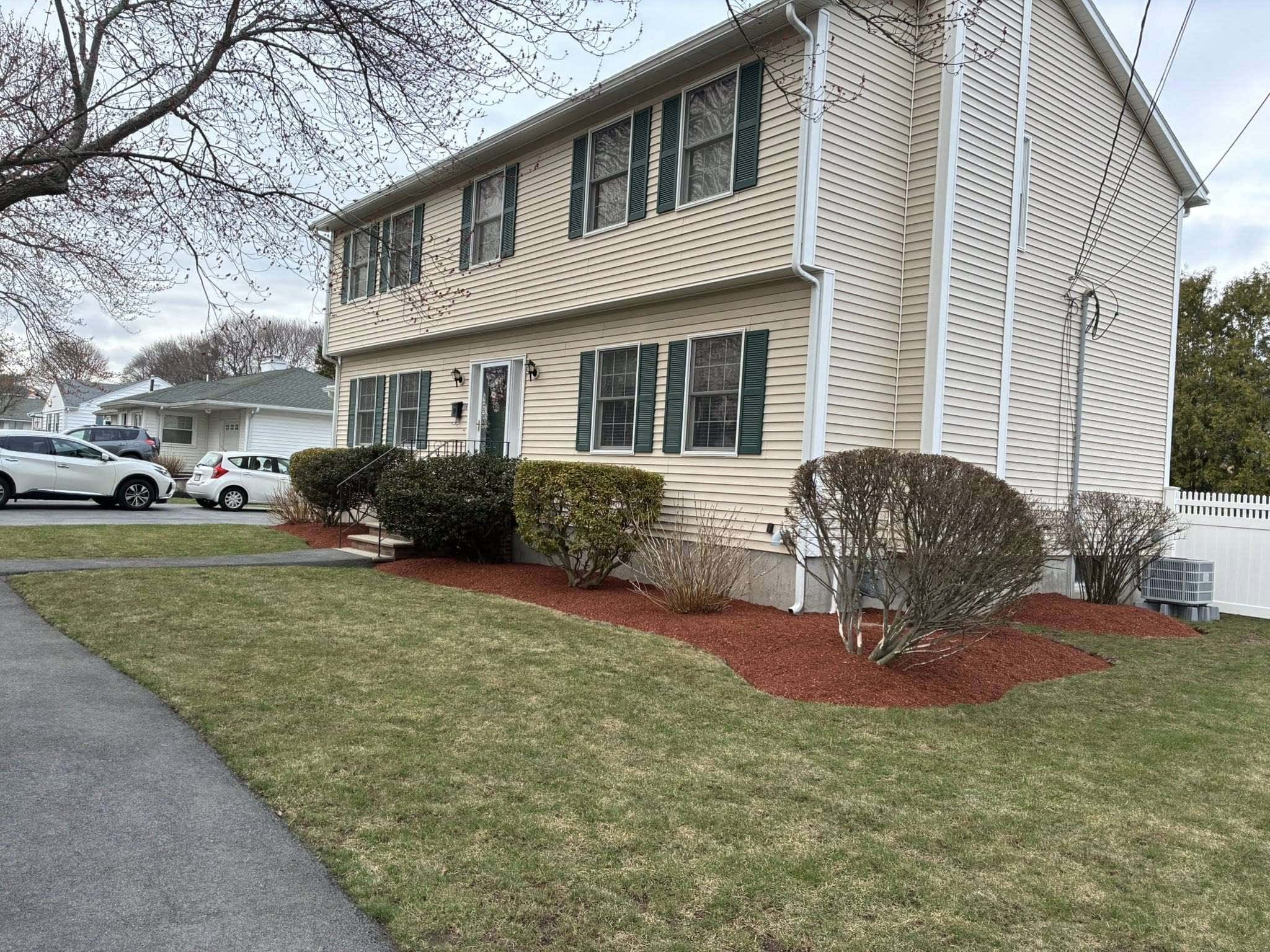 Professionally maintained front yard with trimmed shrubs and healthy residential landscaping